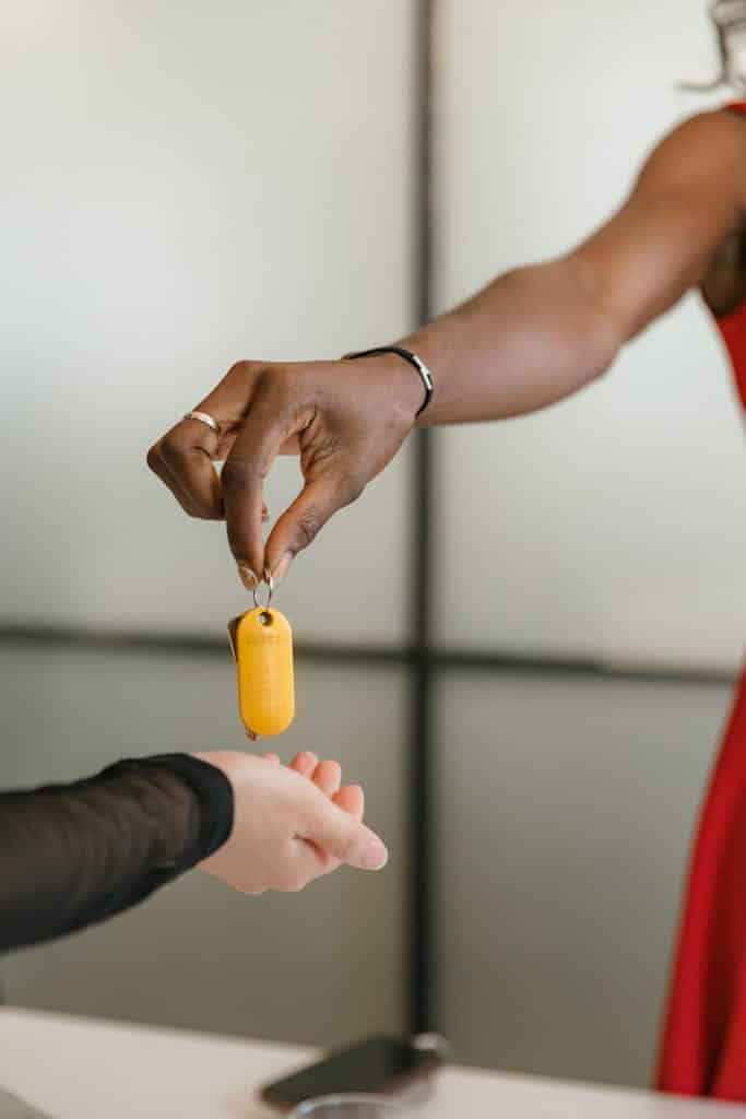 lady handing over a key to a man. Concierge