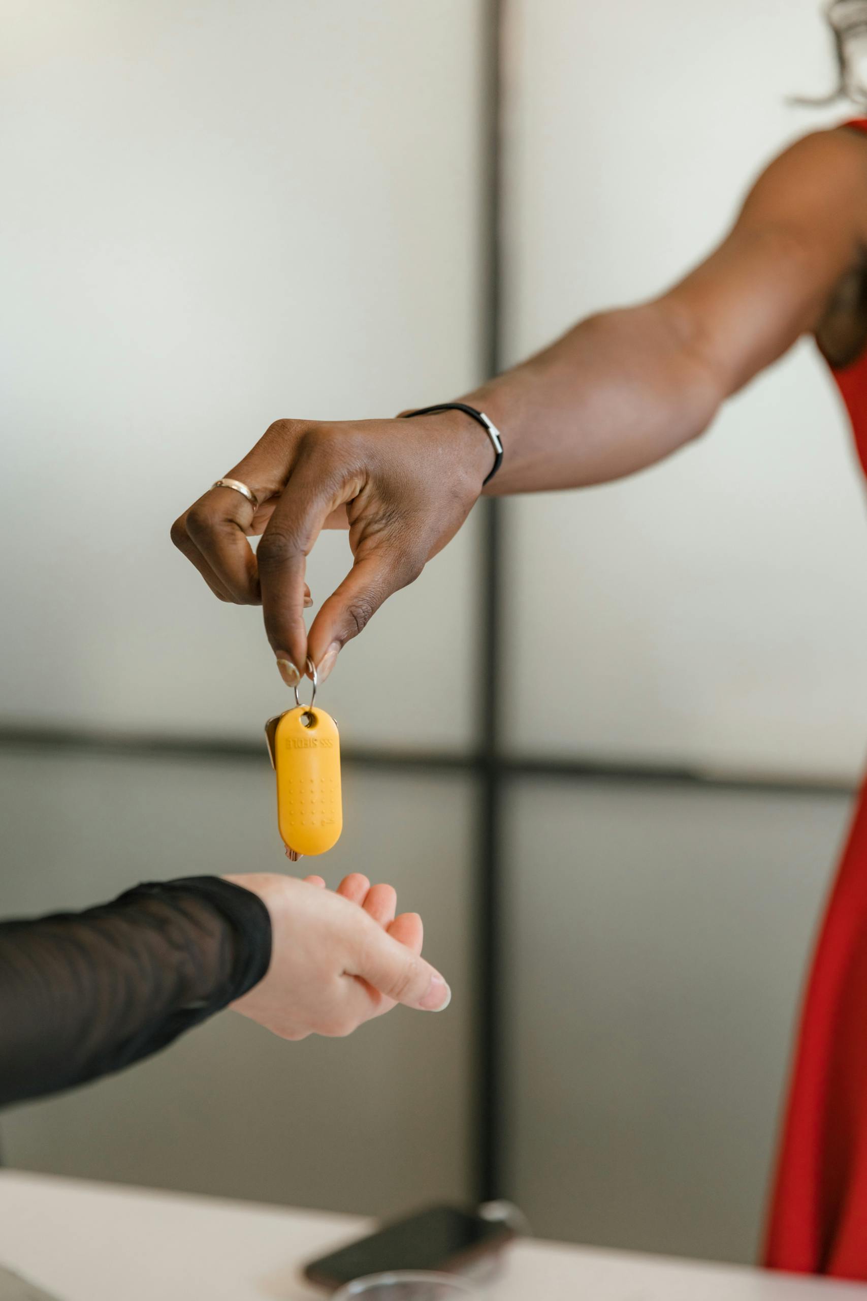 lady handing over a key to a man. Concierge